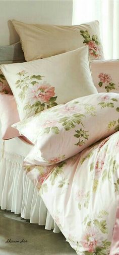 a bed with pink flowers and ruffles on the comforter is shown in front of a window