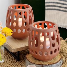 two candles sitting on top of a table next to a vase with flowers in it