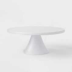 a white cake plate sitting on top of a white tableclothed flooring area