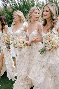 the bridesmaids are all wearing white dresses and holding bouquets in their hands