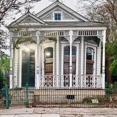 a white house with an iron fence around it