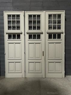 two white double doors in front of a gray wall