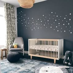 a baby's room with stars painted on the wall and a crib in the foreground