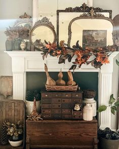 an old dresser with two mirrors above it and other items on top of it in front of a fireplace