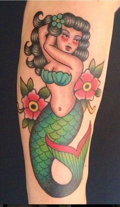 a woman's arm with a mermaid tattoo on it