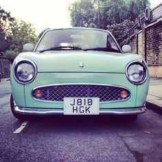 an old green car parked on the street