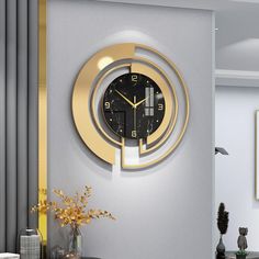 a clock that is on the side of a wall next to a vase with flowers