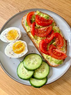 an egg, tomato and cucumber sandwich on a plate