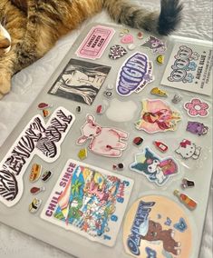 a cat laying on top of a bed covered in stickers