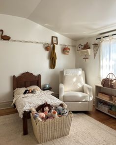 a bedroom with a bed, chair and stuffed animals