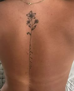 a woman's back with a flower tattoo on it