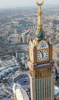 an aerial view of a clock tower in the middle of a city with snow around it