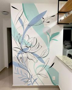 the wall is painted with blue and white flowers in an open kitchen area next to a counter