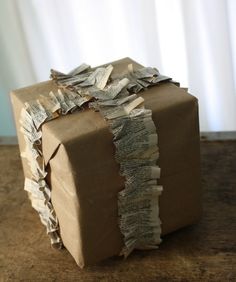 a brown box covered in paper sitting on top of a wooden table