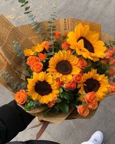 a bouquet of sunflowers is being held by someone