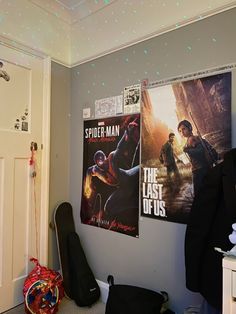 a room with posters on the wall and a guitar case in front of it,