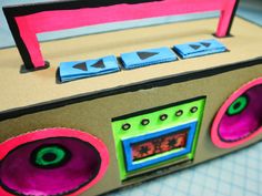 a cardboard box with an old fashioned radio on it's side, cut out to look like a boombox