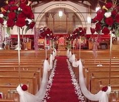 the aisle is decorated with red and white flowers