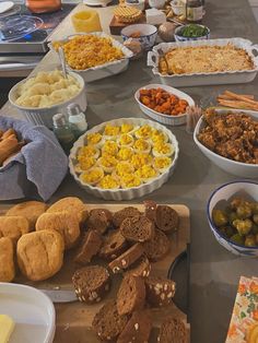 a table full of food including breads, muffins and other foods on it