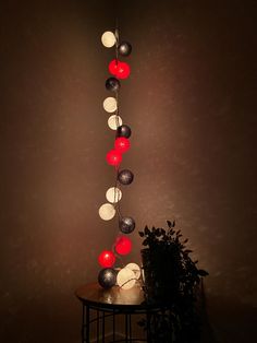 a table with some lights on it and a potted plant in front of it