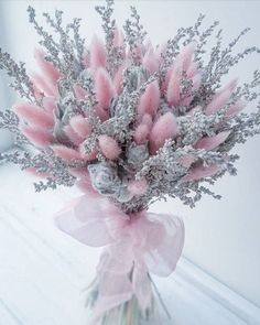 a vase filled with pink and silver flowers