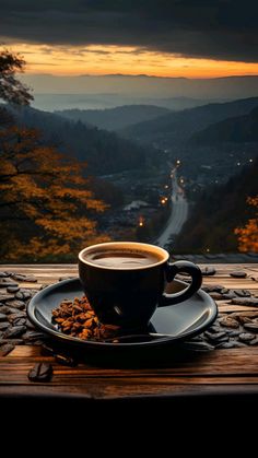 a cup of coffee sitting on top of a wooden table