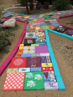 a colorful walkway made out of different colored blocks and pieces of paper on the ground