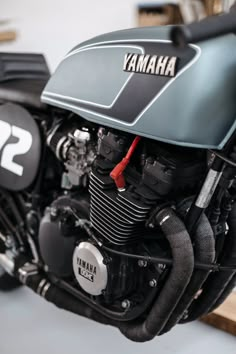 a yamaha motorcycle parked in a garage next to a wooden shelf with other items on it