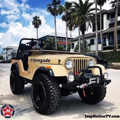 the jeep is parked on the side of the road in front of some palm trees