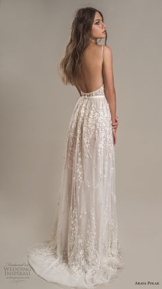 the back of a woman wearing a white wedding dress with floral appliques on it