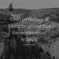 a man standing on top of a cliff with a quote above it that reads, don't let the fear of losing be greater than the excitement of winning