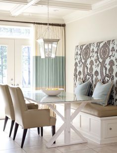 a dining room table with six chairs and a bench in front of the glass door