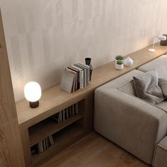 a living room with a couch, bookshelf and lamp on the side wall