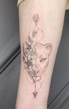 a tattoo on the leg of a woman with flowers and an animal's head