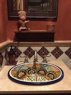 a bathroom sink with an ornate design on the counter top and below it is a mirror