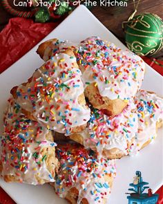 a white plate topped with donuts covered in frosting and sprinkles