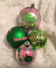 three christmas ornaments are sitting on a white furnishing area with the words skee - wee - wee written on them