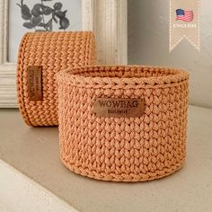 two woven baskets sitting on top of a counter next to a framed photo and an american flag