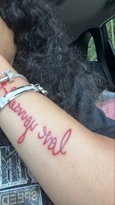 a woman's arm with the word love yoga written on it and two bracelets around her wrist