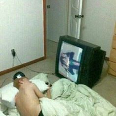 a man laying on the floor in front of a tv