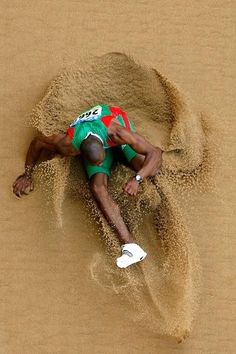 a man laying in the sand on top of a beach