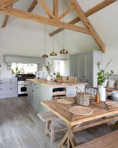 a wooden table sitting in the middle of a kitchen next to a stove top oven