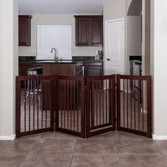 an open gate in the middle of a kitchen with dark wood cabinets and counter tops