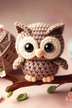 an owl is sitting on a branch with two balls of yarn in front of it