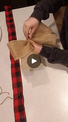 a person is tying a burlap bow on a piece of cloth with scissors