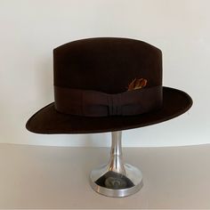 Dark Brown Felt Fedora With Matching Ribbon And Feather. Great Preowned Condition. No Size Tag But Is A 7. Inside Measures 21-7/8" Elegant Brown Flat Bill Hat, Fitted Brown Hat For Kentucky Derby, Formal Fitted Brown Fedora, Fitted Brown Fedora For Winter, Brown Fitted Fedora For Kentucky Derby, Fitted Vintage Brown Fedora, Vintage Fitted Fedora For Fall, Fitted Vintage Fedora For Fall, Formal Fitted Fedora With Flat Bill