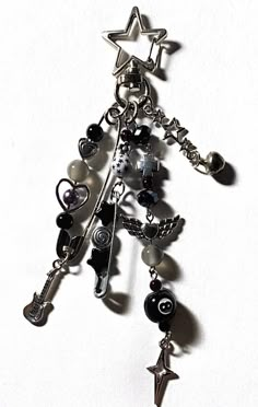 a silver charm with black and white charms on it's side, hanging from a chain