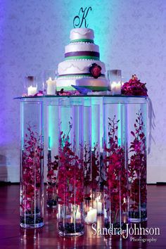 a wedding cake is surrounded by candles and flowers