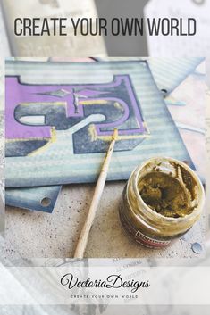 a jar of paint sitting on top of a table next to a brush and paper