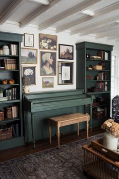 a living room with bookshelves and pictures on the wall above it's fireplace